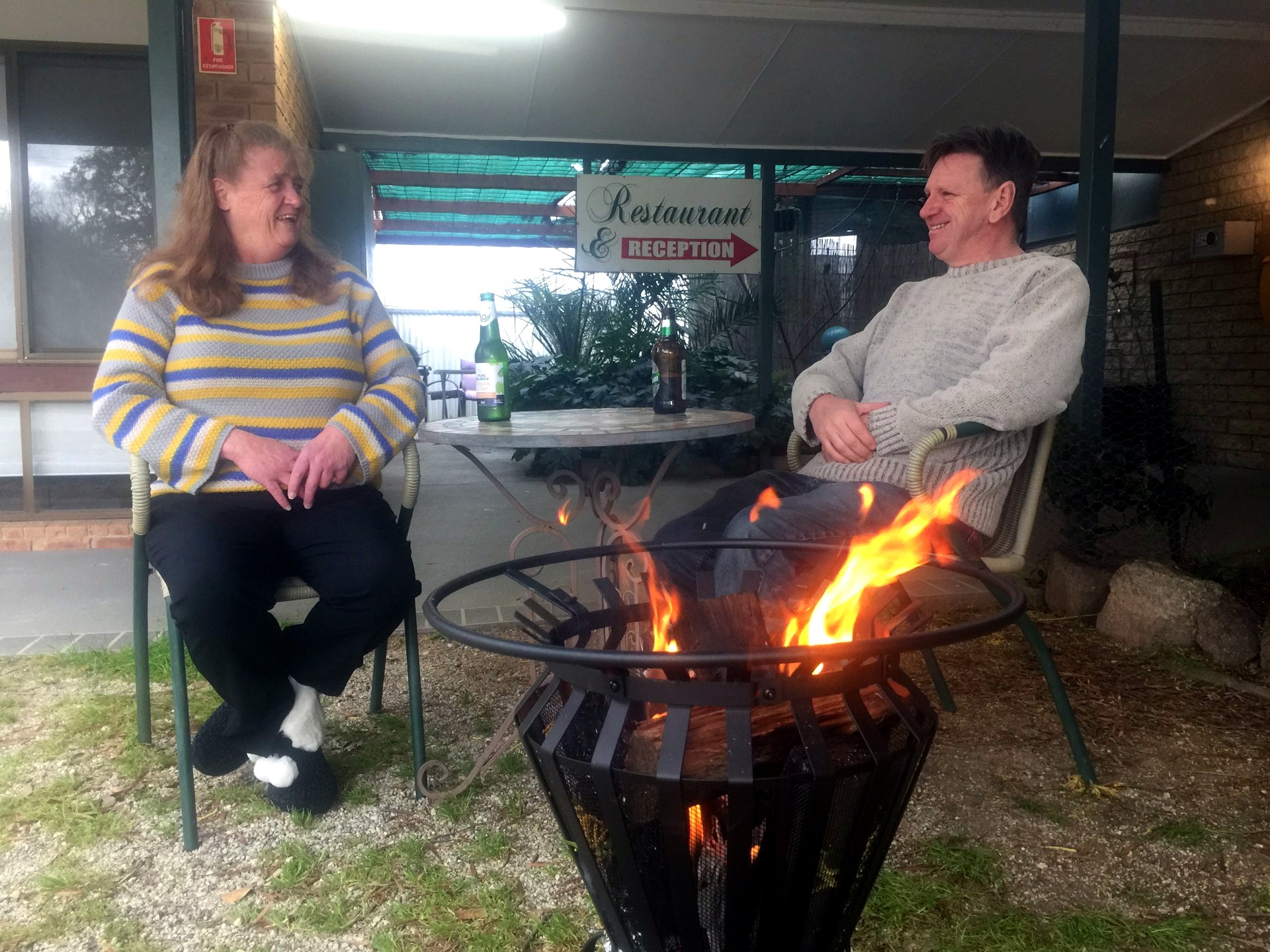Guests sharing a laugh around the courtyard fire pit at Jolly Swagman Motor Inn